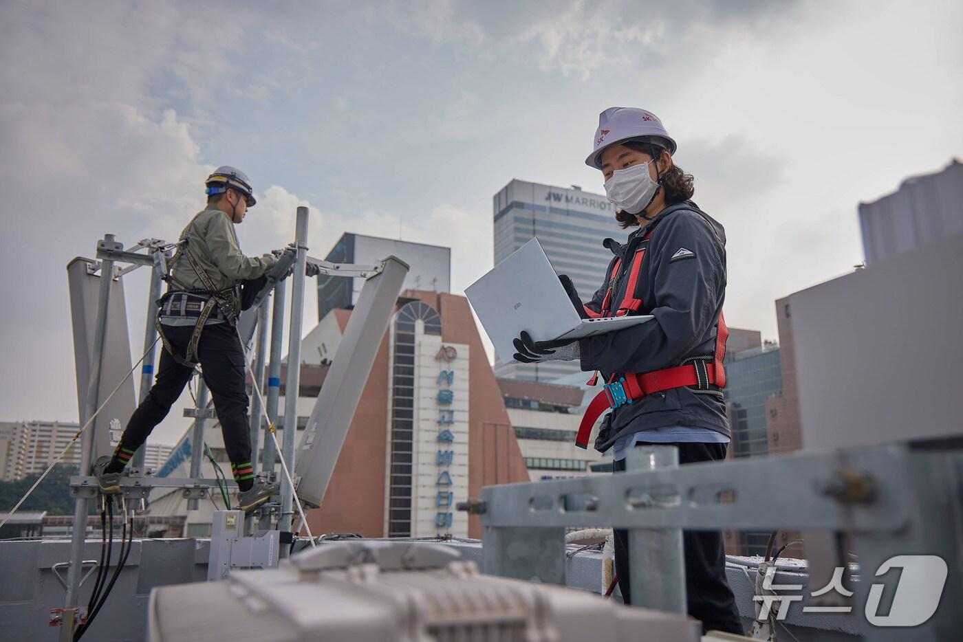 SKT와 SK오앤에스 엔지니어가 고속터미널역 인근에서 통신장비를 점검하는 모습.