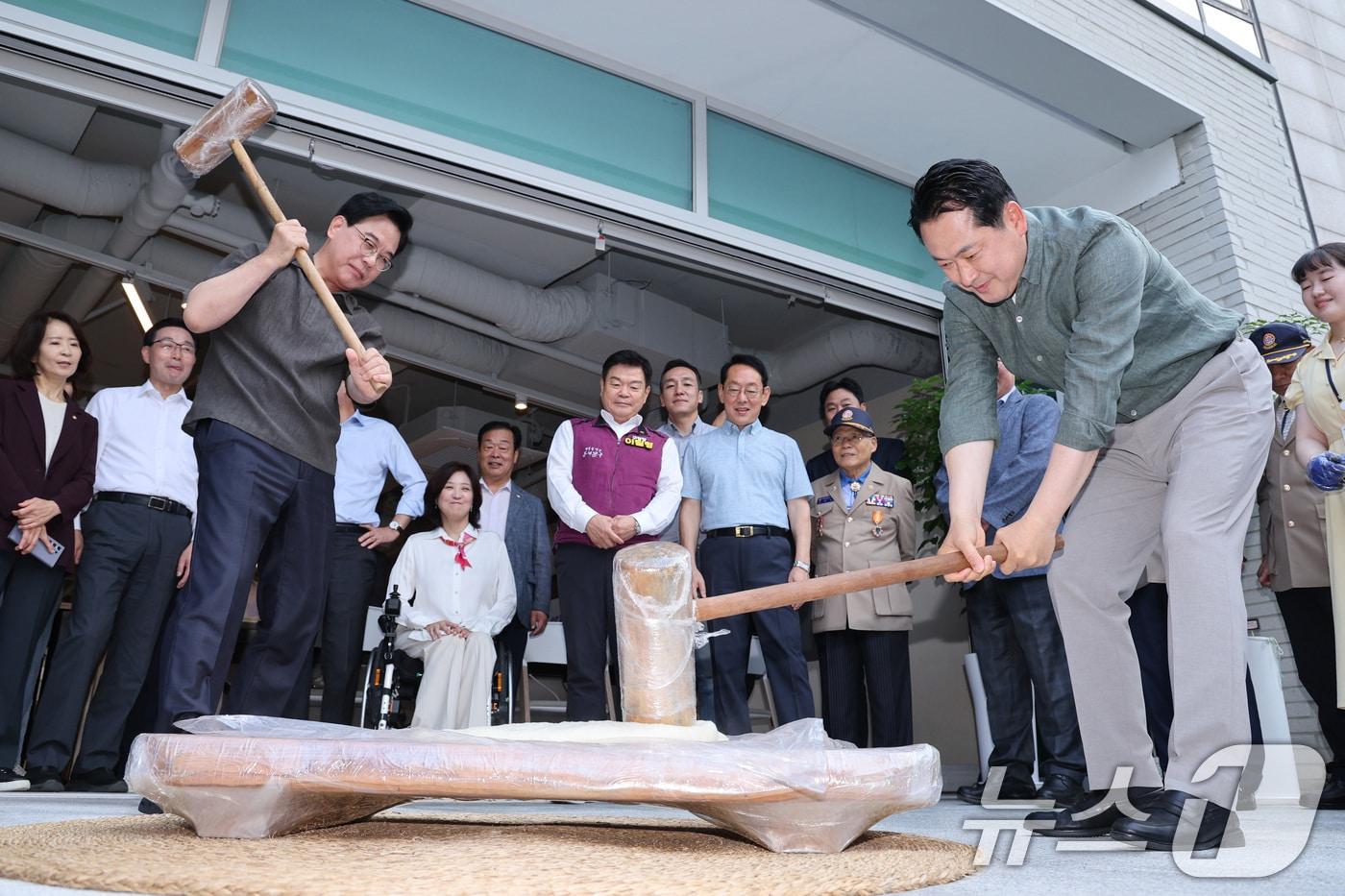 장동혁 국민의힘 대표와 송언석 원내대표가 추석 연휴를 하루 앞둔 2일 서울 동대문구 동백꽃 노인복지관을 찾아 송편을 빚기 위해 떡메를 치고 있다. 2025.10.2/뉴스1 ⓒ News1 신웅수 기자