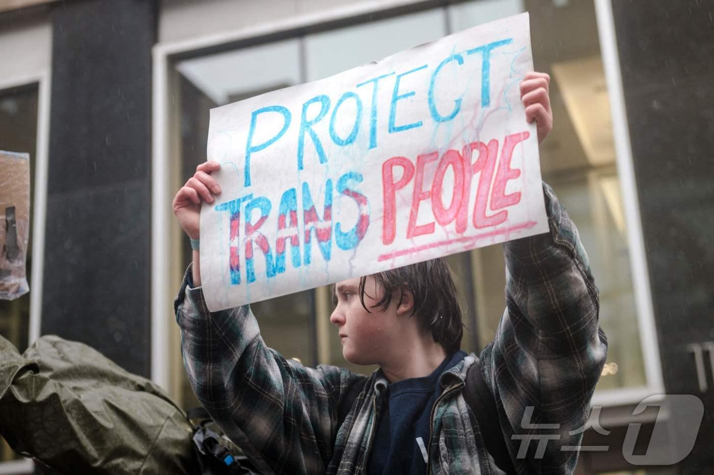 2023년 3월 캐나다 몬트리올 주재 미국 영사관 앞에서 LGBTQ 활동가들이 "트랜스젠더를 보호하라"라고 쓰인 팻말을 들고 시위를 벌이고 있다. <자료사진> ⓒ AFP=뉴스1