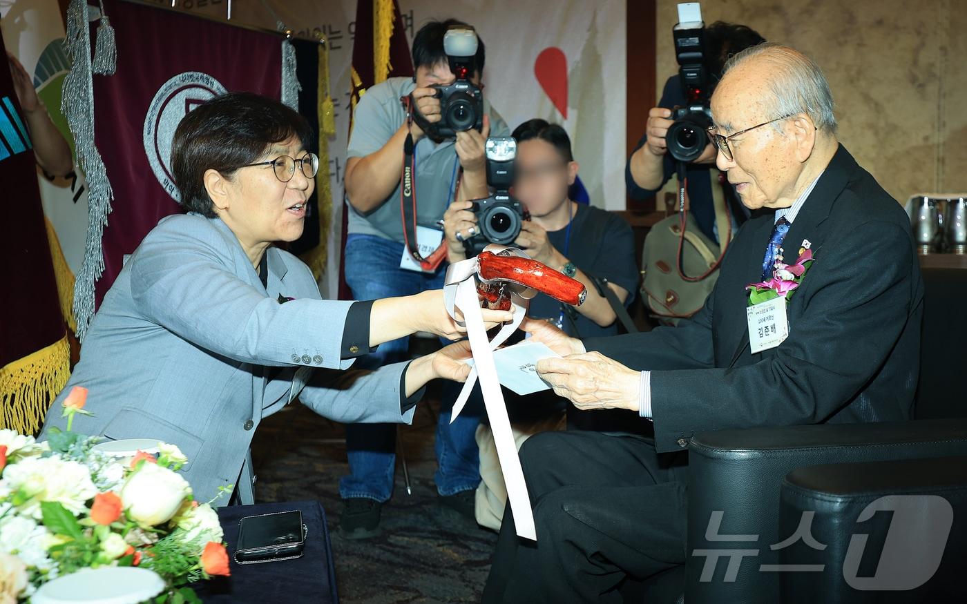 정은경 보건복지부 장관이 2일 서울 중구 소공로 롯데호텔 크리스탈볼룸에서 열린 제29회 노인의날 기념식에서 100세 어르신 대표 김준배 할아버지에게 청려장을 전달하고 있다. 2025.10.2/뉴스1 ⓒ News1 김진환 기자