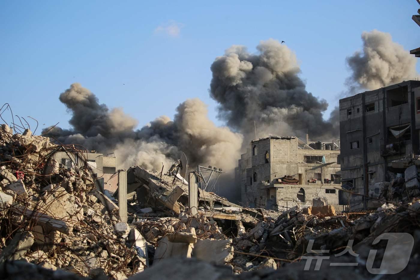 19일&#40;현지시간&#41; 이스라엘의 공습으로 가자지구 중부의 팔레스타인 난민 캠프인 부레이지에서 건물이 무너져 연기가 치솟고 있다. 2025.10.19 ⓒ AFP=뉴스1