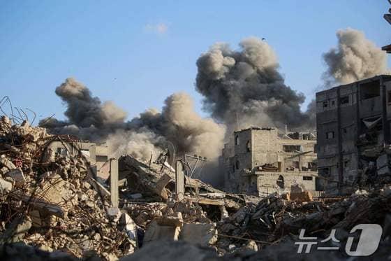 본문 이미지 - 19일&#40;현지시간&#41; 이스라엘의 공습으로 가자지구 중부의 팔레스타인 난민 캠프인 부레이지에서 건물이 무너져 연기가 치솟고 있다. 2025.10.19 ⓒ AFP=뉴스1