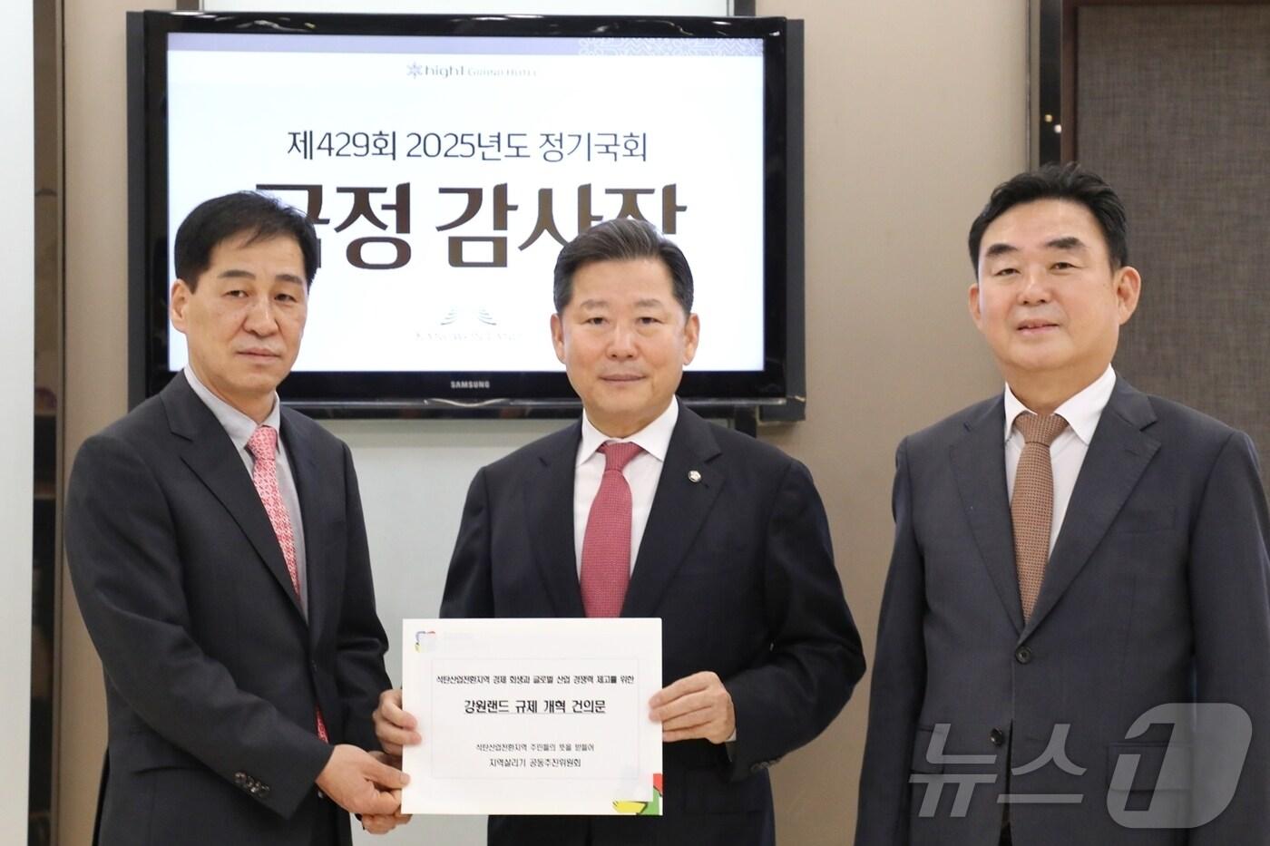 국회 산업통상자원중소벤처기업위원회가 20일 강원랜드의 하이원그랜드호텔에서 국정감사에 나선 가운데, 안승재 정선 고한사북남면신동살리기공동추진위원장&#40;왼쪽&#41;이 이날 감사장을 찾아 이철규 산자위원장&#40;가운데&#41;에게 강원랜드 규제 개혁 건의문을 전달하고, 이 위원장, 최철규 강원랜드 대표이사 직무대행과 기념사진을 촬영하고 있다. &#40;강원랜드 제공. 재판매 및 DB금지&#41; &#41;2025.10.20./뉴스1 2025.10.20/뉴스1 ⓒ News1 신관호 기자