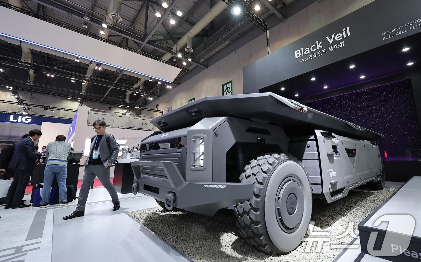 본문 이미지 - 2025년 10월20일 경기 고양시 킨텍스에서 열린 서울국제항공우주 및 방위산업 전시회 'ADEX 2025'에서 현대로템 부스를 찾은 관람객들이 수소연료전지 기반 무인 모빌리티 전동화 플랫폼 '블랙 베일'을 살펴보고 있다. 2025.10.20 ⓒ 뉴스1 김성진 기자