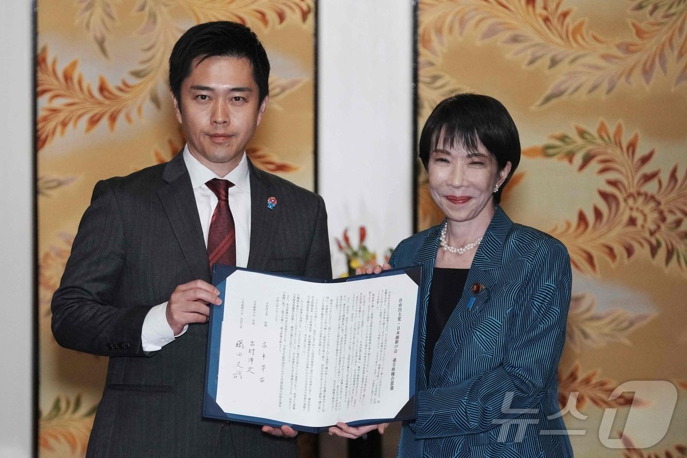 일본 집권 자민당 다카이치 사나에 총재(오른쪽)와 제2야당 일본유신회 요시무라 히로후미 대표가 20일 연정 수립 합의문을 들고 있다.2025.10.20. ⓒ AFP=뉴스1