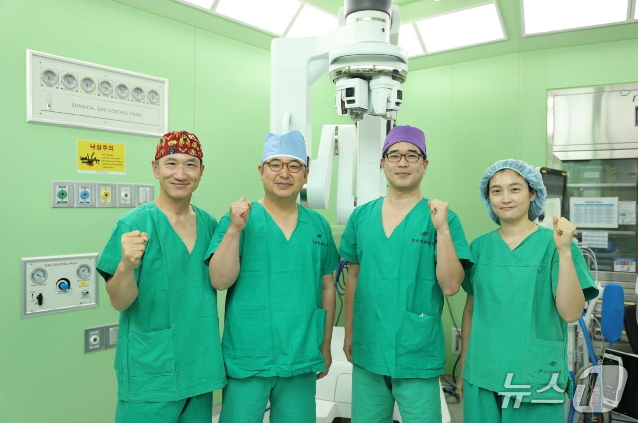 본문 이미지 - 한림대학교강남성심병원 로봇수술센터 교수진 다빈치SP 앞에서 기념촬영을 하고 있다.&#40;한림대학교강남성심병원 제공&#41;