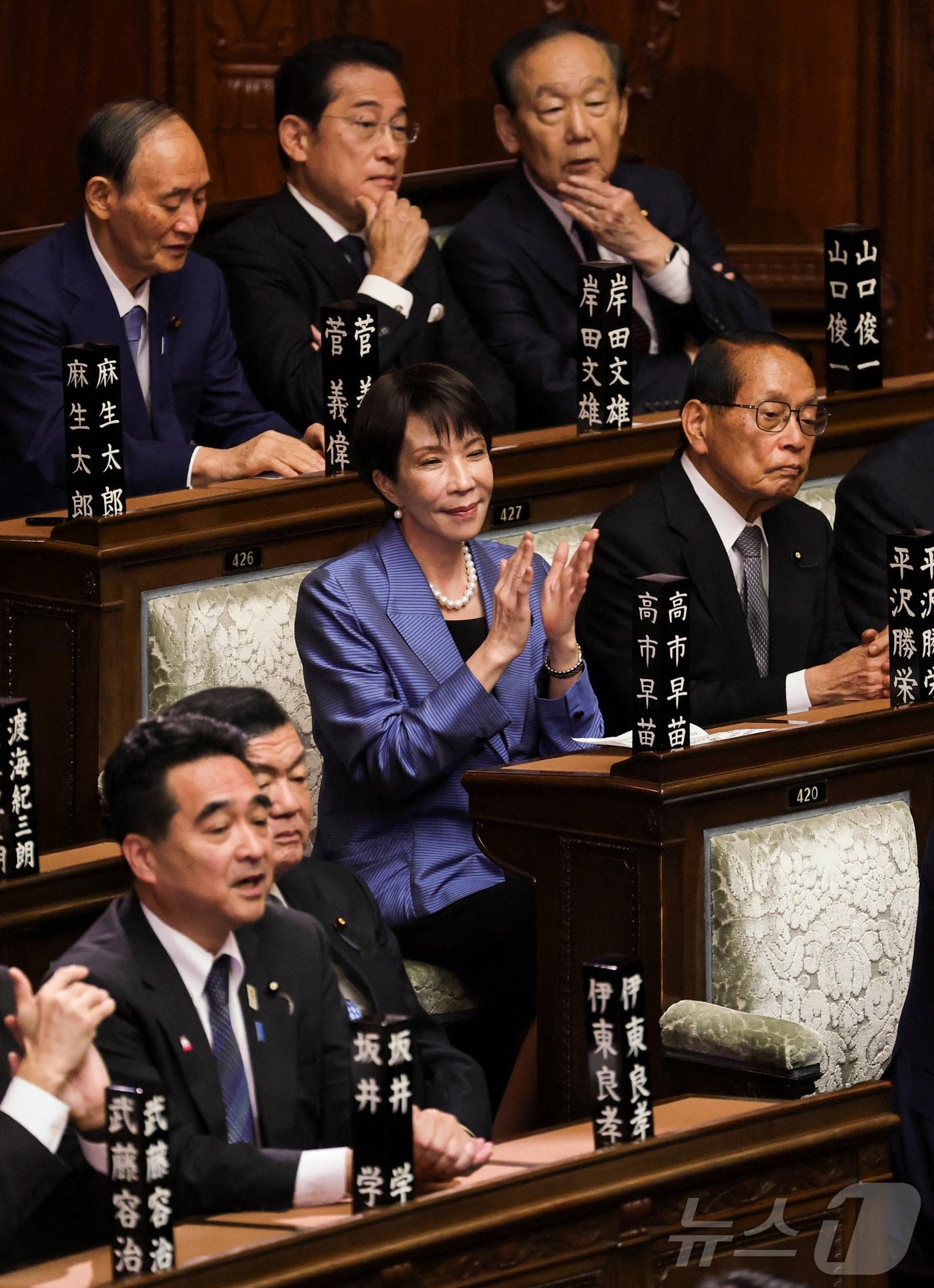 본문 이미지 - 다카이치 사나에 자민당 총재(가운데)가 21일 임시국회에서 총리 지명 선거를 앞두고 의석에서 대기하고 있다. 2025.10.21 ⓒ 로이터=뉴스1 ⓒ News1 강민경 기자