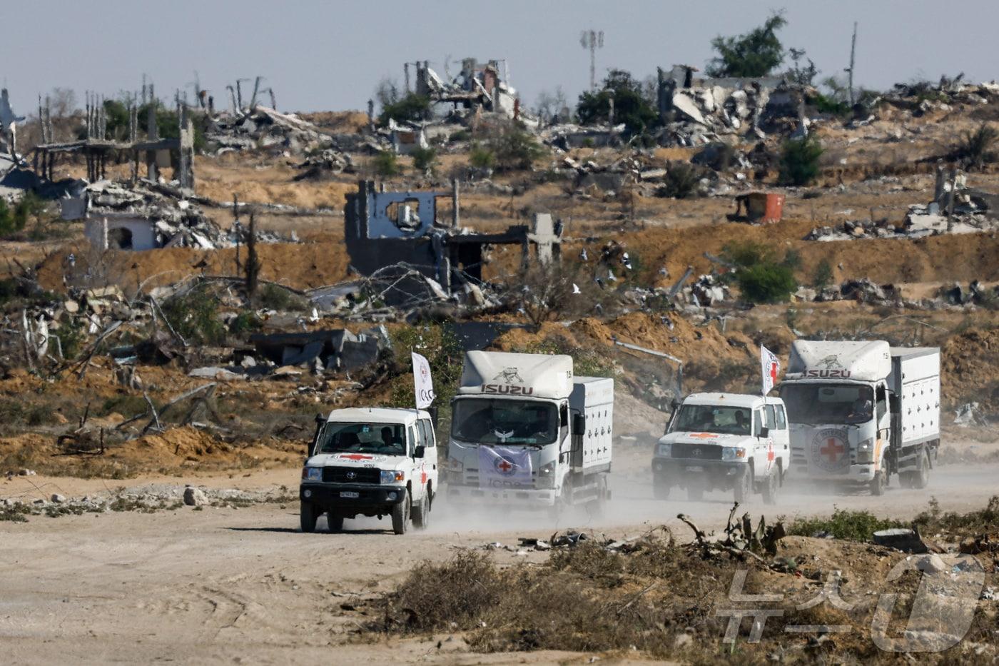 15일(현지시간) 팔레스타인 가자지구 남부 칸 유니스에서 적십자 차량들이 이스라엘에 구금됐던 팔레스타인 사망자들의 시신을 인도하고 있다. 2025.10.15. ⓒ 로이터=뉴스1 ⓒ News1 윤다정 기자