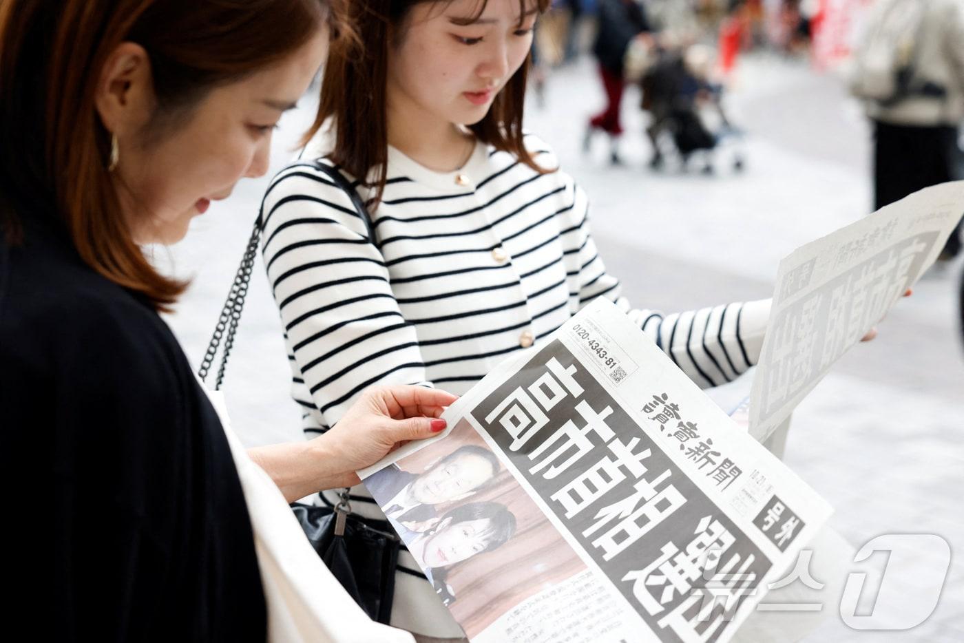 본문 이미지 - 일본 도쿄 거리에서 21일 다카이치 사나에 자민당 총재가 일본의 첫 여성 총리로 선출됐다는 요미우리 신문의 호외 기사를 여성들이 읽고 있다. 2025.10.21 ⓒ 로이터=뉴스1 ⓒ News1 최종일 선임기자