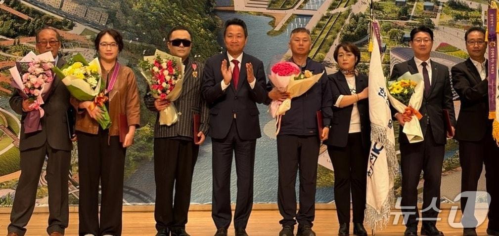 본문 이미지 - 21일 울산시청에서 제46회 세계 흰지팡이의 날 기념 시각장애인 복지증진대회가 열린 가운데 근로복지공단 사회봉사단 관계자들이 울산시장 표창을 수상한 뒤 기념 사진을 찍고 있다. &#40;근로복지공단 제공. 재판매 및 DB 금지&#41; /뉴스1