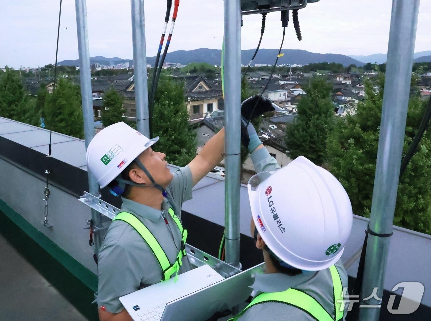 본문 이미지 - LG유플러스는 이달 말 경주에서 열리는 APEC 정상회의에 많은 인파가 몰릴 것을 대비해 경주시 일대 주요 시설에 추가 통신 장치를 구축하고, 전용 상황실을 운영한다. 사진은 경주 황리단길 인근 통신 장비를 점검하는 LG유플러스 직원의 모습.