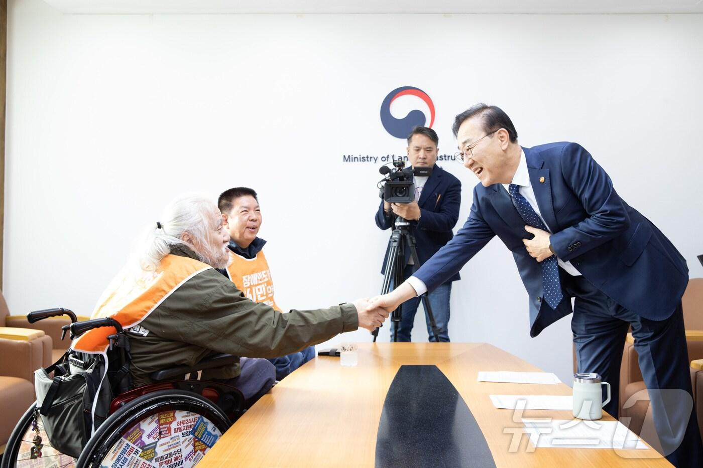 김윤덕 국토교통부 장관이 22일 서울 국토발전전시관에서 박경석 전국장애인차별철폐연대 대표와 악수를 하고 있다. &#40;국토교통부 제공. 재판매 및 DB금지&#41; 2025.10.22/뉴스1