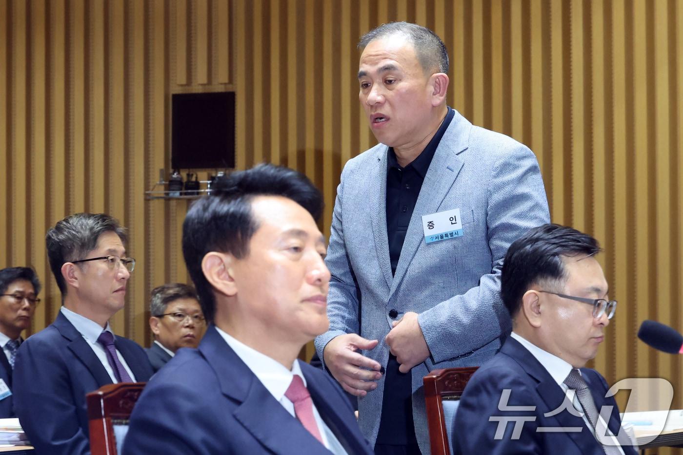 &#39;정치 브로커&#39; 명태균씨가 23일 오후 서울 중구 서울시청에서 열린 국회 행정안전위원회 서울시청 국정감사에서 의원질의를 마치고 오세훈 서울시장 뒤로 이동하고 있다. 2025.10.23/뉴스1 ⓒ News1 황기선 기자