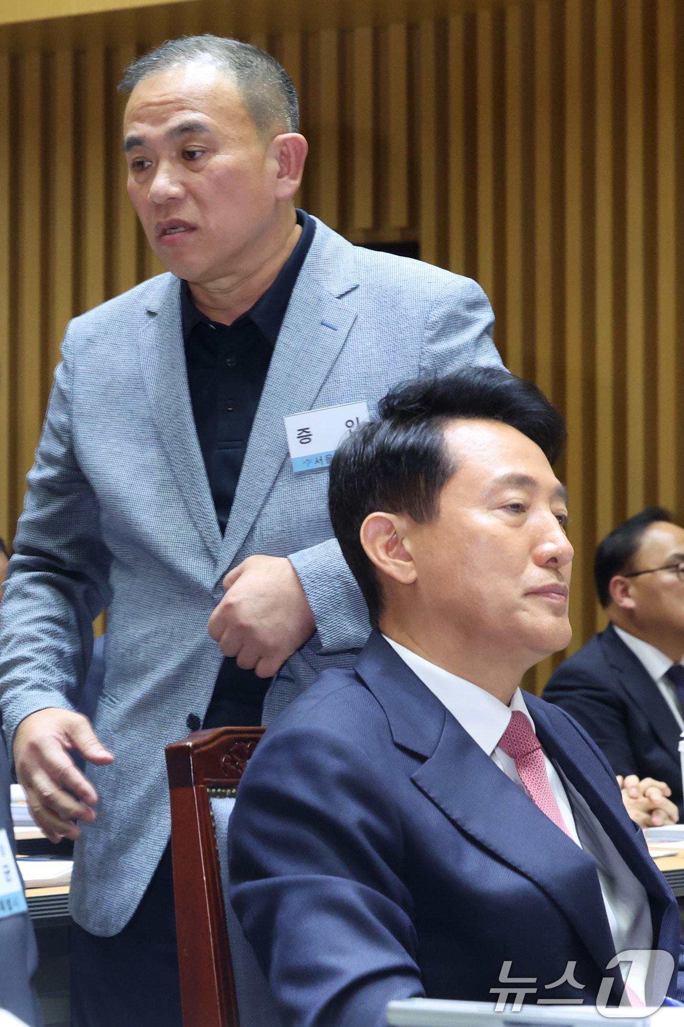 본문 이미지 - '정치 브로커' 명태균씨가 지난 23일 오후 서울 중구 서울시청에서 열린 국회 행정안전위원회 서울시청 국정감사에서 의원질의를 마치고 오세훈 서울시장 뒤로 이동하고 있다. 2025.10.23/뉴스1 ⓒ News1 황기선 기자