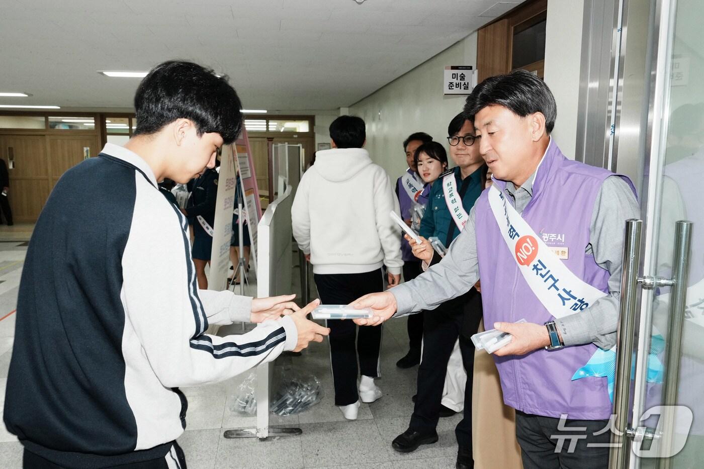 방세환 시장이 23일 탄벌중에서 진행된 학교폭력 예방 캠페인에서 학생들에게 학교폭력 예방 홍보 물품을 전달하고 있다.(광주시 제공)