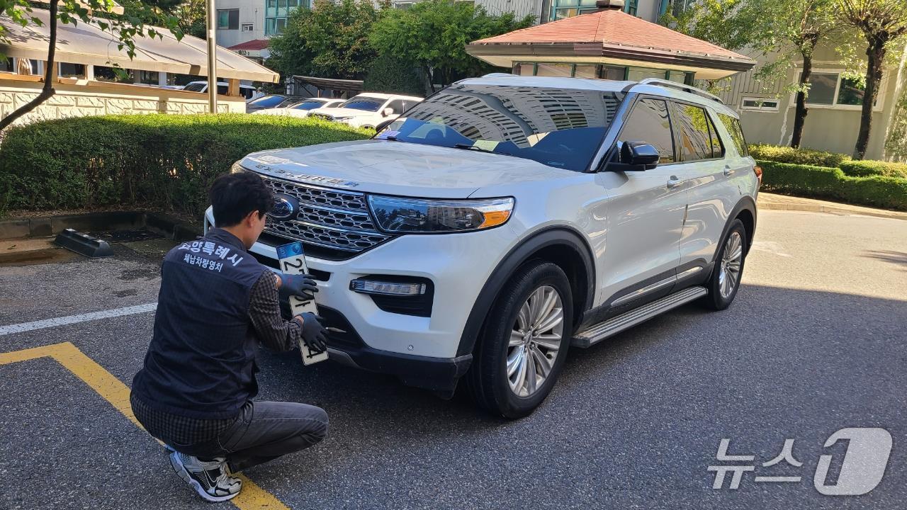 본문 이미지 - 고양시 관계자가 체납차량에 대한 번호판을 영치하고 있는 모습. &#40;고양시 제공, 재판매 및 DB금지&#41;