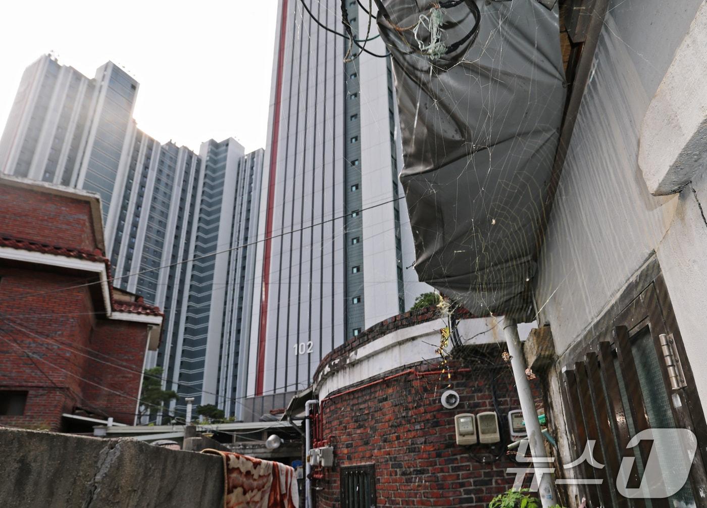 본문 이미지 - 정부의 10·15 부동산 대책 발표 이후 서울을 중심으로 거래절벽과 매물 잠김 현상이 뚜렷해지고 있다. 토지거래허가구역과 투기과열지구 확대 지정, 고가주택 대출 규제 강화에 이어 보유세 인상 가능성까지 거론되면서 매수·매도자 모두 '일단 멈춤'에 들어갔다. 사진은 24일 서울 노원구 상계5 재정비촉진구역의 노후 주택 뒤로 고층 아파트가 들어선 모습. 2025.10.24/뉴스1 ⓒ News1 오대일 기자