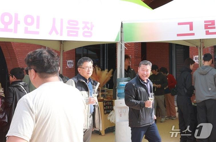 본문 이미지 - 제6회 예밀와인축제가 25일 강원 영월군 김삿갓면 예밀와인 방문자센터 일원에서 열린 가운데, 이날 축제장을 찾은 한 방문객이 와인잔을 들고 일행과 이동하고 있다. &#40;영월군 제공. 재판매 및 DB금지&#41; 2025.10.25/뉴스1