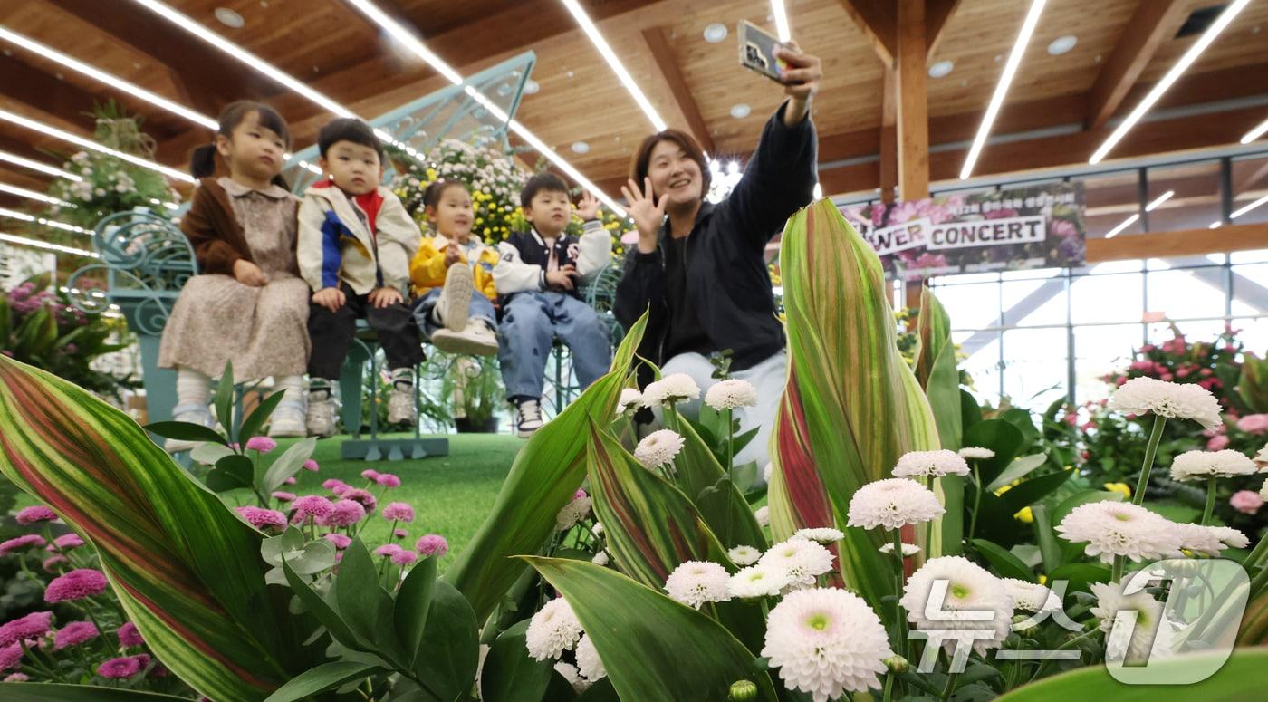 26일 경기 수원시 영통구 영흥수목원에서 열린 ‘제12회 장미·국화 생생전시회’에서 아이들이 다양한 국화와 장미를 보며 가을 정취를 느끼고 있다. 이번 전시회에는 경기도농업기술원이 자체 개발한 ‘핑크아미’ ‘캐롤라인’ 같은 장미 38종과 ‘펄키스타’‘마이엘프’ 등 국화 29종이 선보인다. 장미와 국화 모두 절화와 분화 형태로 전시되며 관람객을 대상으로 한 기호도 조사를 통해 향후 유망 품종 선발에도 활용될 예정이다. 2025.10.26/뉴스1 ⓒ News1 김영운 기자