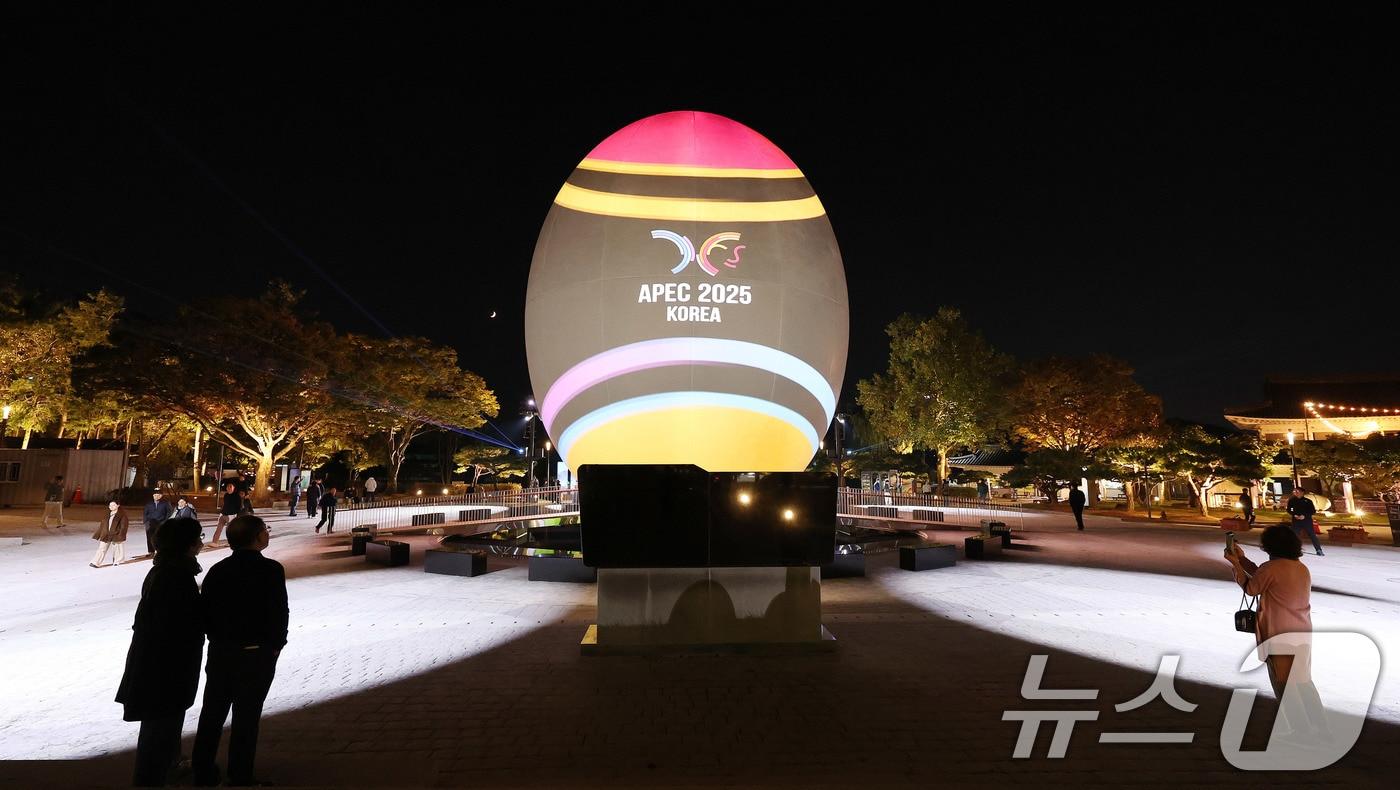 2025년 아시아태평양경제협력체(APEC) 정상회의 주간 개막을 하루 앞둔 26일 오후 경북 경주시 보문단지 호반광장에 설치된 높이 15m의 APEC 상징조형물(신라 시조 박혁거세의 탄생 알 형상)에 화려한 미디어아트가 상영되며 경주의 밤하늘을 밝히고 있다. 2025.10.26/뉴스1 ⓒ News1 박지혜 기자
