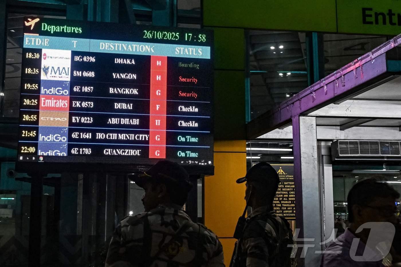 26일 인도 콜카타의 네타지 수바스 찬드라 보스 국제공항에서 보안 요원이 항공편 안내판 근처에 서 있다. 인도와 중국은 이날 5년 만에 직항 노선을 재개했다.2025.10.26. ⓒ AFP=뉴스1