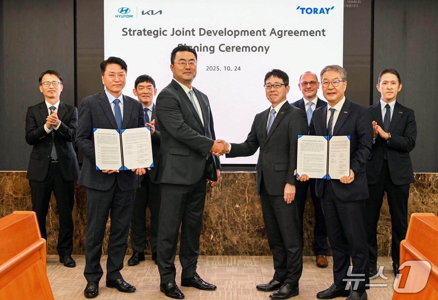 본문 이미지 -  현대차그룹은 지난 24일 도레이그룹과 전략적 공동 개발 계약(Strategic Joint Development Agreement)을 체결했다고 27일 밝혔다. 사진은 현대차그룹 GSO본부장 김흥수 부사장(왼쪽에서 네번째), 도레이그룹 테라다 미키 복합재료사업본부 부문장(왼쪽에서 다섯번째)이 체결식 이후 기념사진을 촬영하는 모습.(현대차그룹 제공)