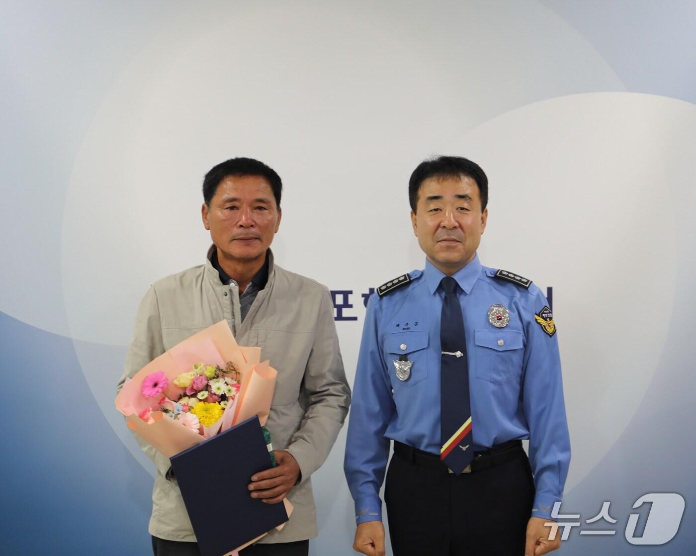 본문 이미지 - 채수준 목포해양경찰서장(오른쪽)이 27일 전복된 어선에서 생명을 구한 황동연 선장(63)에게 표창장을 수여한 뒤 기념사진을 찍고 있다. (목포해경 제공. 재판매 및 DB 금지)