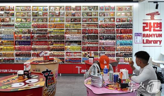 본문 이미지 - 지난 7월 3일 서울 마포구 CU 홍대상상점 라면 라이브러리를 찾은 외국인들이 라면을 먹고 있다. &#40;서울=뉴스1&#41; 김도우 기자