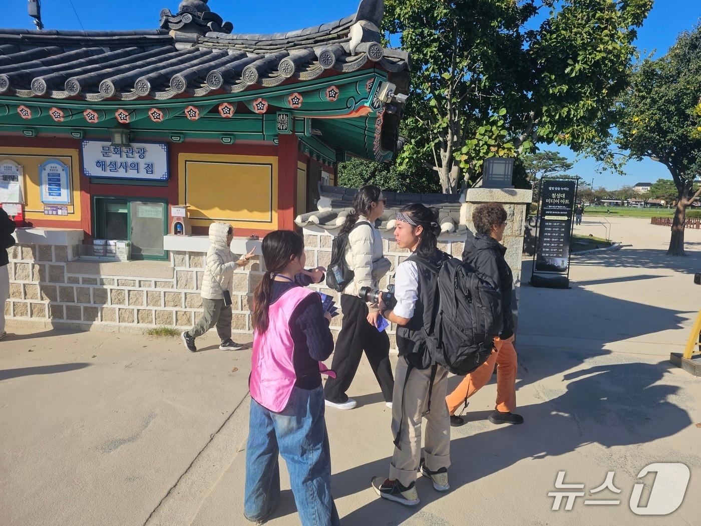 본문 이미지 - APEC 개막 첫날인 27일 경주 첨성대 앞에서 한 통역자원봉사자가 외국인 관광객을 안내하고 있다.(2025.10.27/뉴스1 신성훈기자