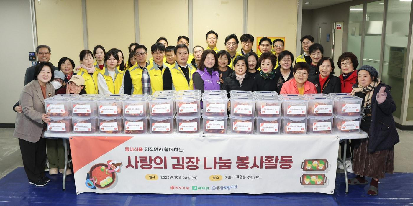  동서식품이 지난 28일 서울시 마포구 대흥동주민센터에서 다문화·한부모 가정과 함께하는 김장 봉사활동을 진행했다. 사진은 봉사활동에 참여한 동서식품 직원들이 단체사진을 찍고 있는 모습.(동서식품 제공) 