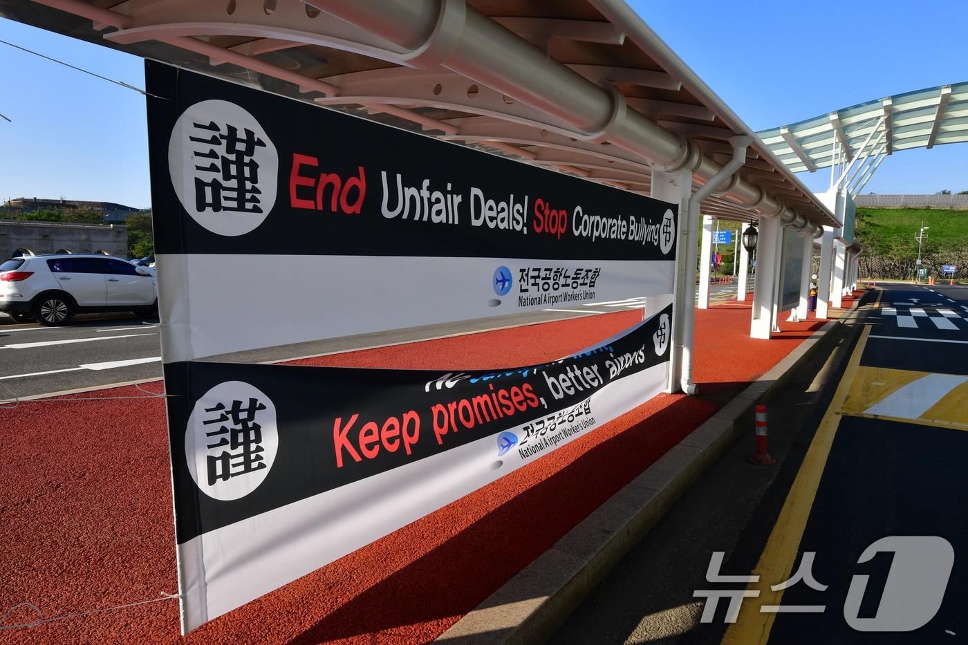 본문 이미지 - 29일 APEC 글로벌 CEO 전용공항인 경북 포항경주공항 입구에 영문으로 된 전국공항 환경미화 주차, 전기 설비 노동자들의 파업, 근조 현수막이 걸려있다. 2025.10.29/뉴스1 ⓒ News1 최창호 기자