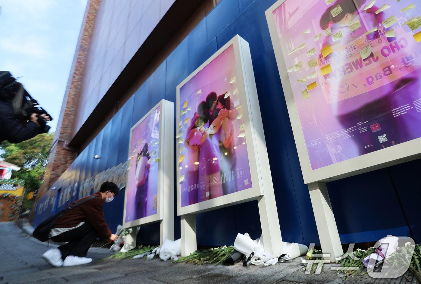 본문 이미지 - 10·29 이태원 참사 3주기를 맞은 29일 오전 서울 용산구 이태원 참사 현장 골목에서 한 시민이 헌화를 하고 있다. 2025.10.29 ⓒ 뉴스1 오대일 기자