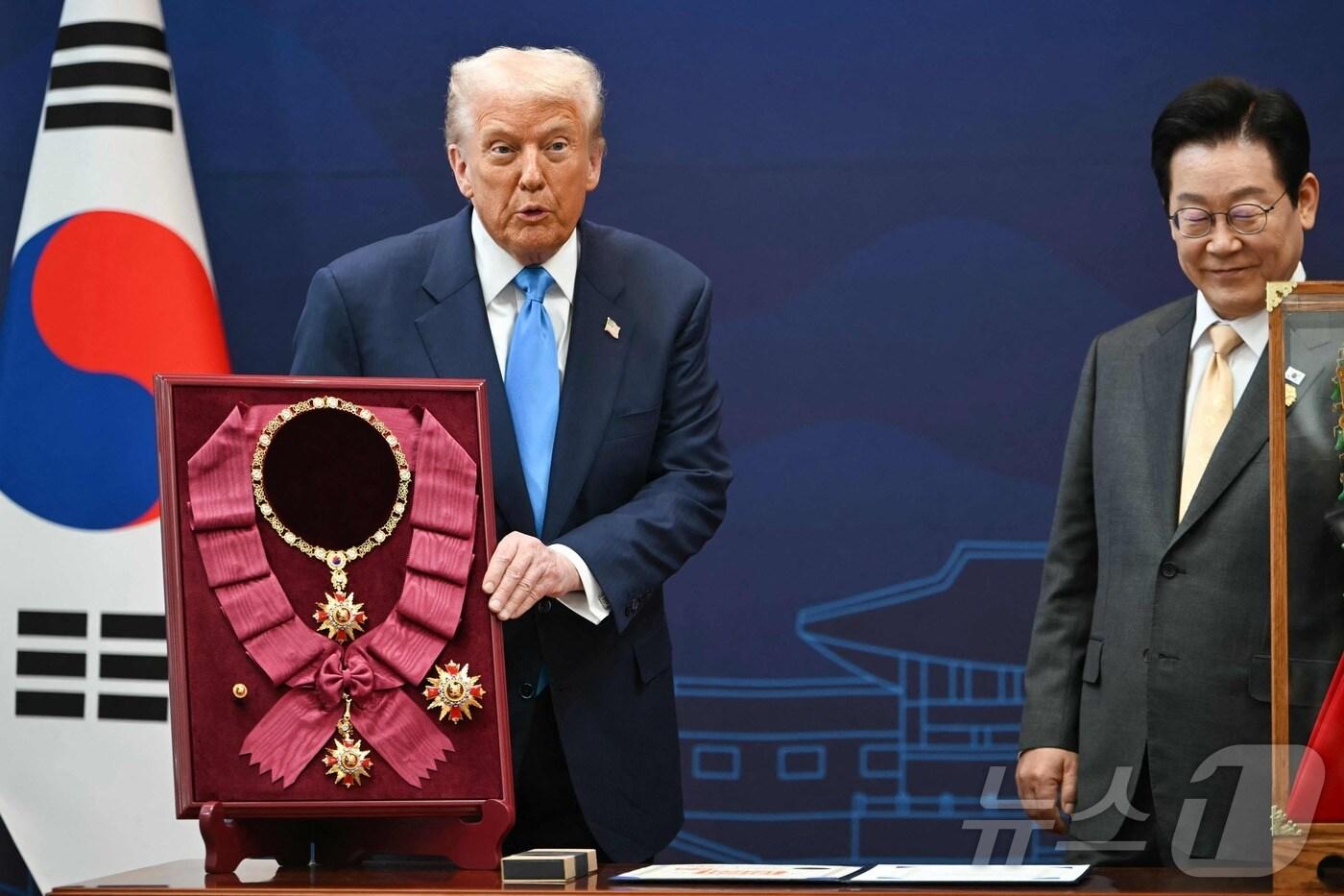 이재명 대통령이 29일 경북 경주박물관에서 열린 한미 공식 환영식에서 도널드 트럼프 미국 대통령에게 무궁화 대훈장을 수여하고 있다. ⓒ AFP=뉴스1