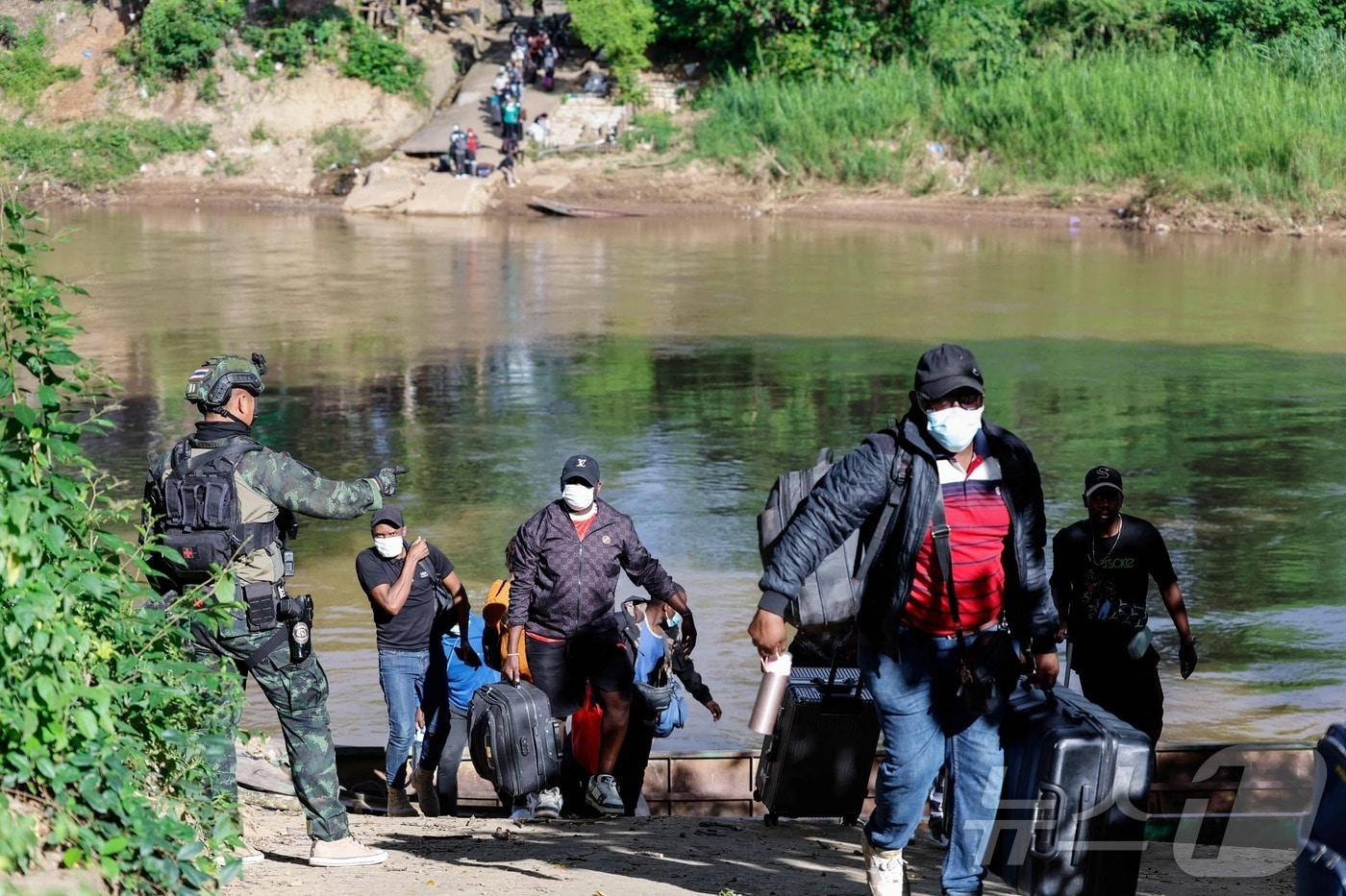 24일&#40;현지시간&#41; 미얀마 KK 파크 단지에서 일하던 근로자들이 짐을 들고 모에이 강을 건너 태국으로 피신하고 있다. 2025.10.24. ⓒ AFP=뉴스1 ⓒ News1 이정환 기자