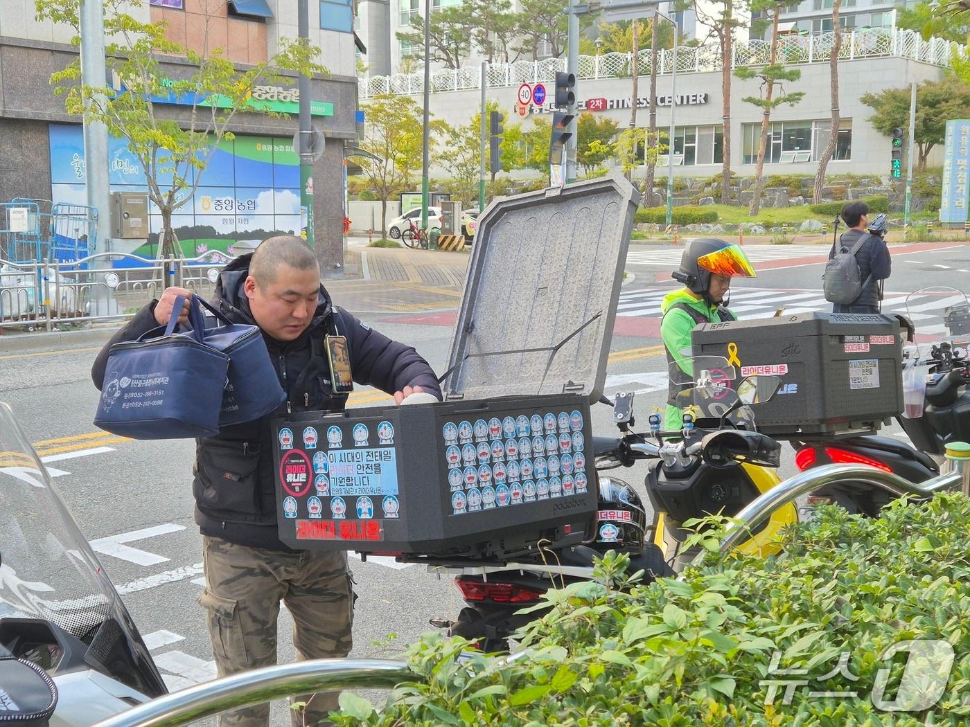 본문 이미지 - 황기진 라눔 단장이 29일 울산중구종합사회복지관 앞에서 이륜차 뒤 상자에 도시락을 넣고 있다. 2025.10.29 /뉴스1 ⓒ 뉴스1 박정현 기자