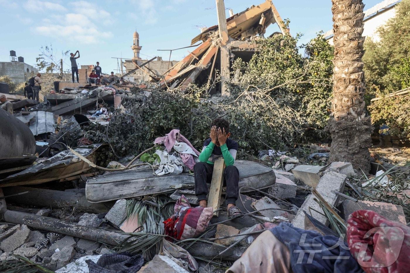 29일&#40;현지시간&#41; 가자지구 중부 누세이라트에서 이스라엘 공습으로 파괴된 집의 잔해에 앉아 한 소년이 울고 있다. 2025.10.29 ⓒ AFP=뉴스1 ⓒ News1 김경민 기자