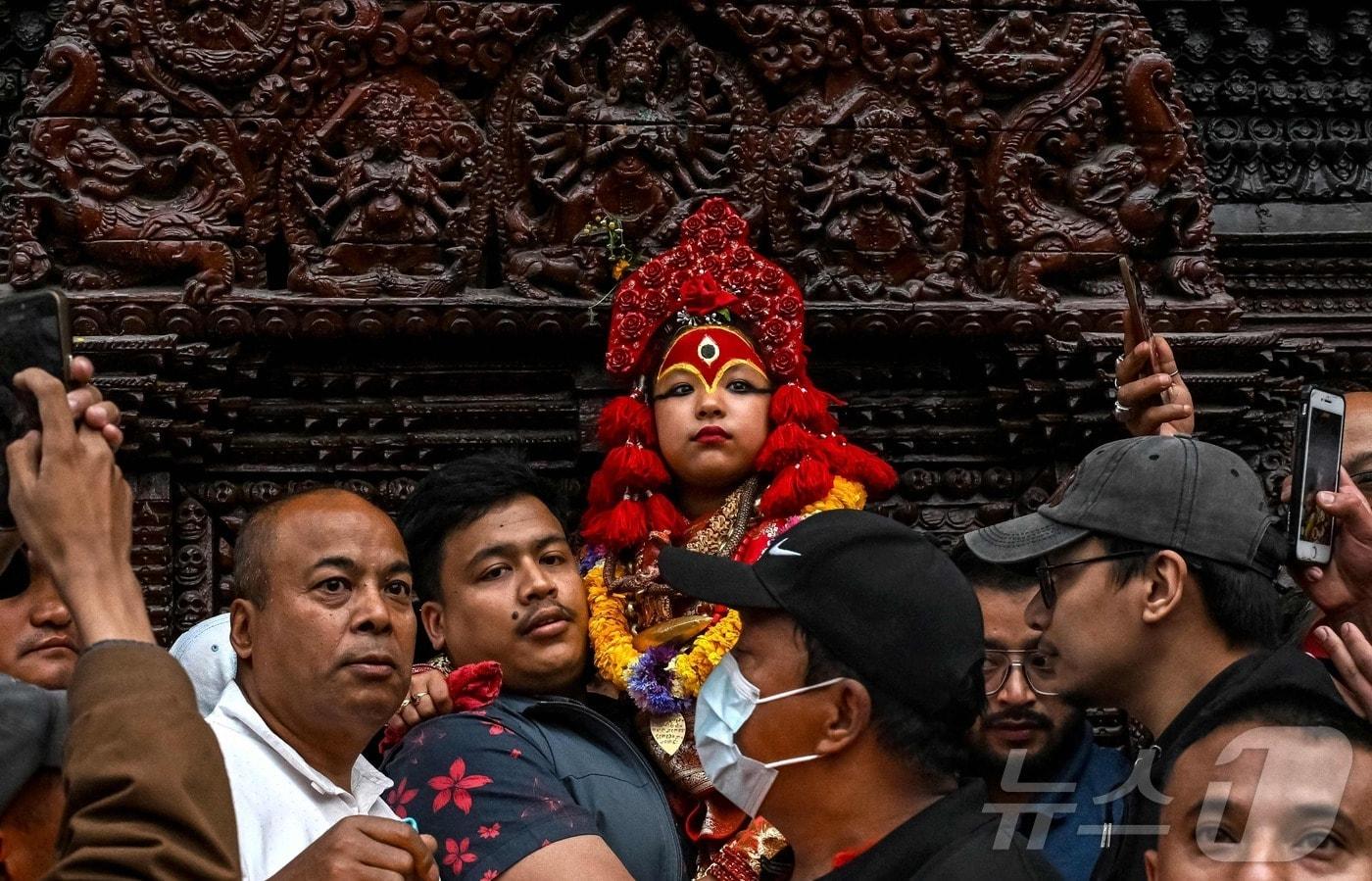 4월 7일(현지시간) 네팔 카트만두에서 열린 세토 마친드라나트 수레 축제 셋째 날 신도들이 살아 있는 여신 '쿠마리 데비'를 안아 옮기고 있다. 2025.04.07. ⓒ AFP=뉴스1 ⓒ News1 윤다정 기자
