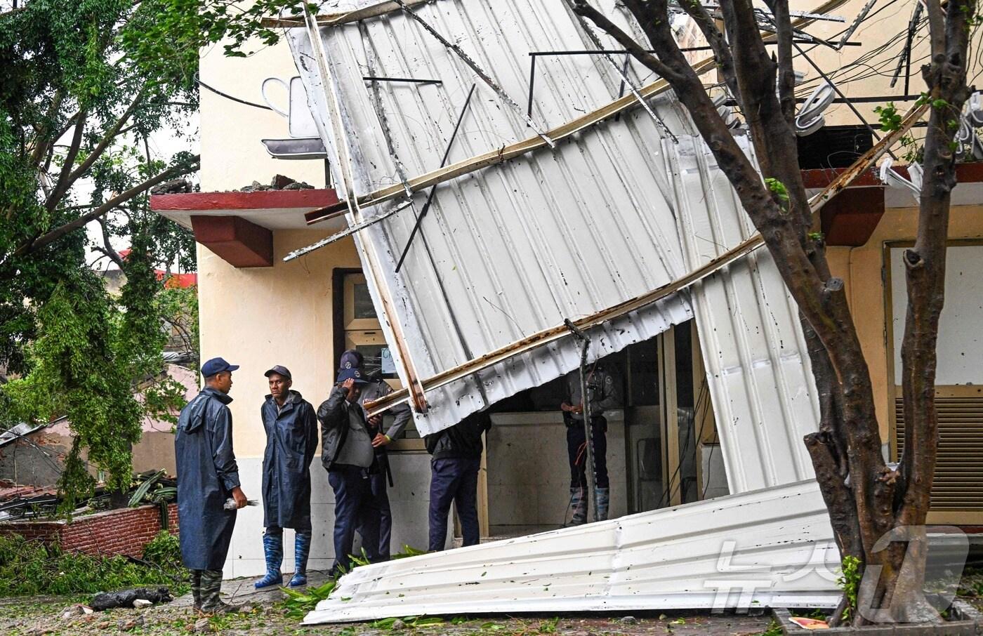 29일 쿠바 동부 산티아고데쿠바 지역에 허리케인 멜리사가 상륙하면서 주택과 도로에 침수 및 피해가 발생했다. AFP 현장 취재진에 따르면, 강력한 허리케인의 영향으로 국영 건물이 파손됐으며, 경찰이 해당 건물 외부를 경비하고 있는 모습. 2025.10.29.ⓒ AFP=뉴스1