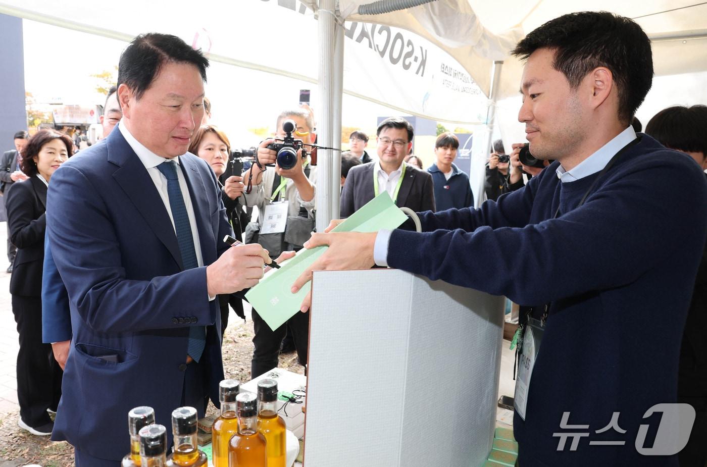 최태원 대한상의 회장이 사회적 기업 제품에 싸인을 하고 있다. 사진 왼쪽부터 최태원 대한상의 회장, 정경선 현대해상 CSO (사진제공 = 대한상공회의소) 