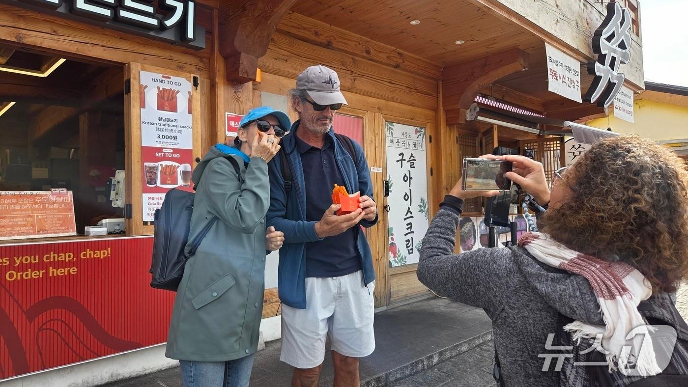 31일 경북 경주 대표 관광지인 황리단길에 방문한 외국인 관광객이 간식 &#39;황남쫀드기&#39;를 들고 기념 사진을 촬영하고 있다.2025.10.31/뉴스1 ⓒ News1 이성덕 기자