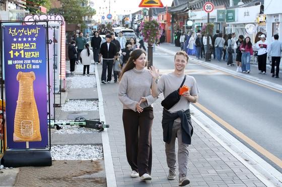 본문 이미지 - 31일 오후 경주시 황남동 황리단길을 찾은 외국인 관광객이 취재진을 향해 손을 흔들며 인사하고 있다. 황리단길은 경주 황남동과 서울 이태원 경리단길을 합쳐 ‘황남동의 경리단길’이라는 뜻을 담고 있다. 십원빵·첨성대빵·쫀드기 등 다양한 간식을 비롯해 먹거리, 카페, 식당, 기념품샵, 한복대여점, 사진관, 타로사주카페 등 다양한 콘텐츠를 갖춘 핫플레이스로 인기를 얻고 있다. 2025.10.31 ⓒ 뉴스1 공정식 기자