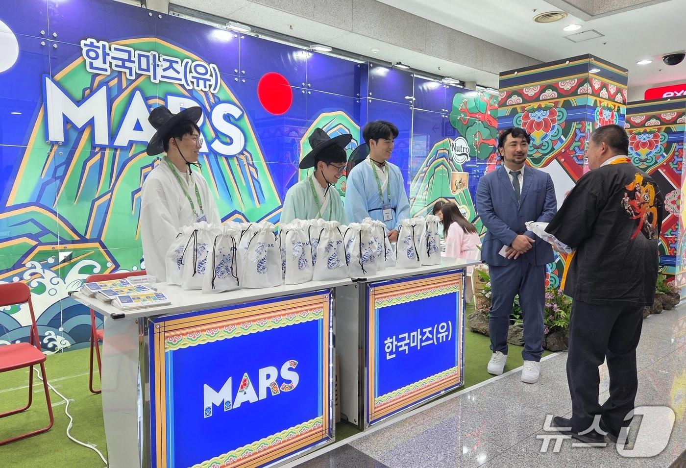 2025 FASAVA에 참가한 한국마즈는 넷플릭스 애니메이션 영화 '케이팝 데몬헌터스'에서 영감을 받아 부스를 꾸몄다. 심용희 한국마즈 수의사와 직원들이 부스에 방문한 외국인에게 제품을 홍보하고 있다. ⓒ 뉴스1 한송아 기자