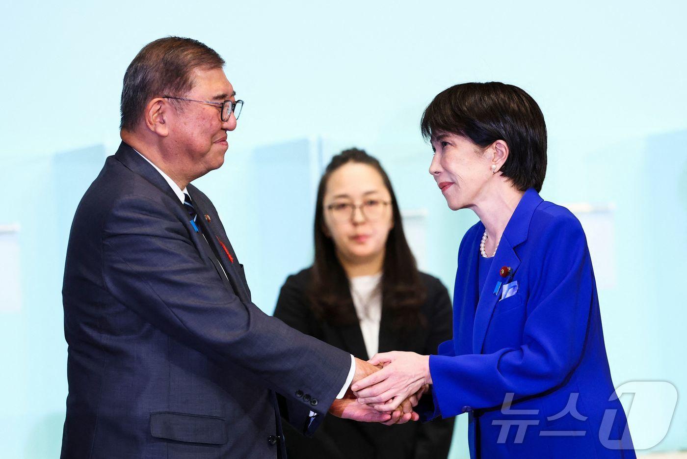 지난 10월 4일 일본 자민당 총재 선거에서 당선된 다카이치 사나에 총리가 이시바 시게루 당시 총리와 악수하고 있다. 2025.10.04 ⓒAFP=뉴스1