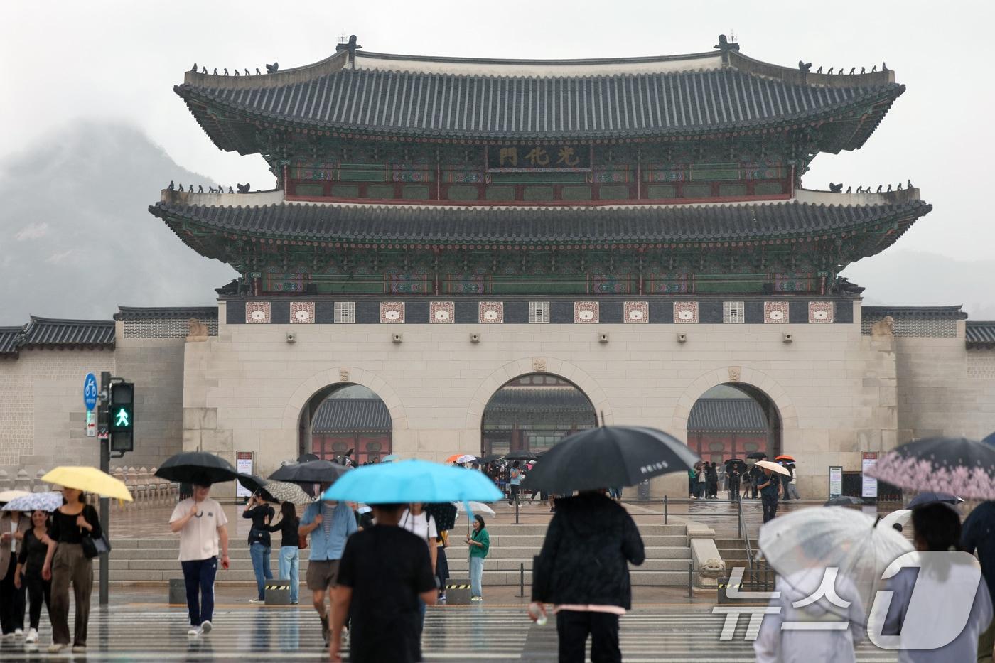 추석 명절을 하루 앞둔 5일 오전 서울 광화문 앞에서 외국인 관광객과 시민들이 우산을 들고 발걸음을 옮기고 있다. 2025.10.5/뉴스1 ⓒ News1 황기선 기자