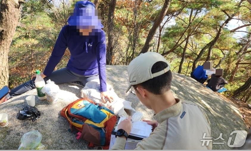 본문 이미지 - 북한산국립공원 특별사법경찰이 자연공원법 금지행위&#40;고지대 음주행위&#41;를 위반한 탐방객을 단속하고 있다.&#40;국립공원공단 제공, 재판매 및 DB금지&#41;