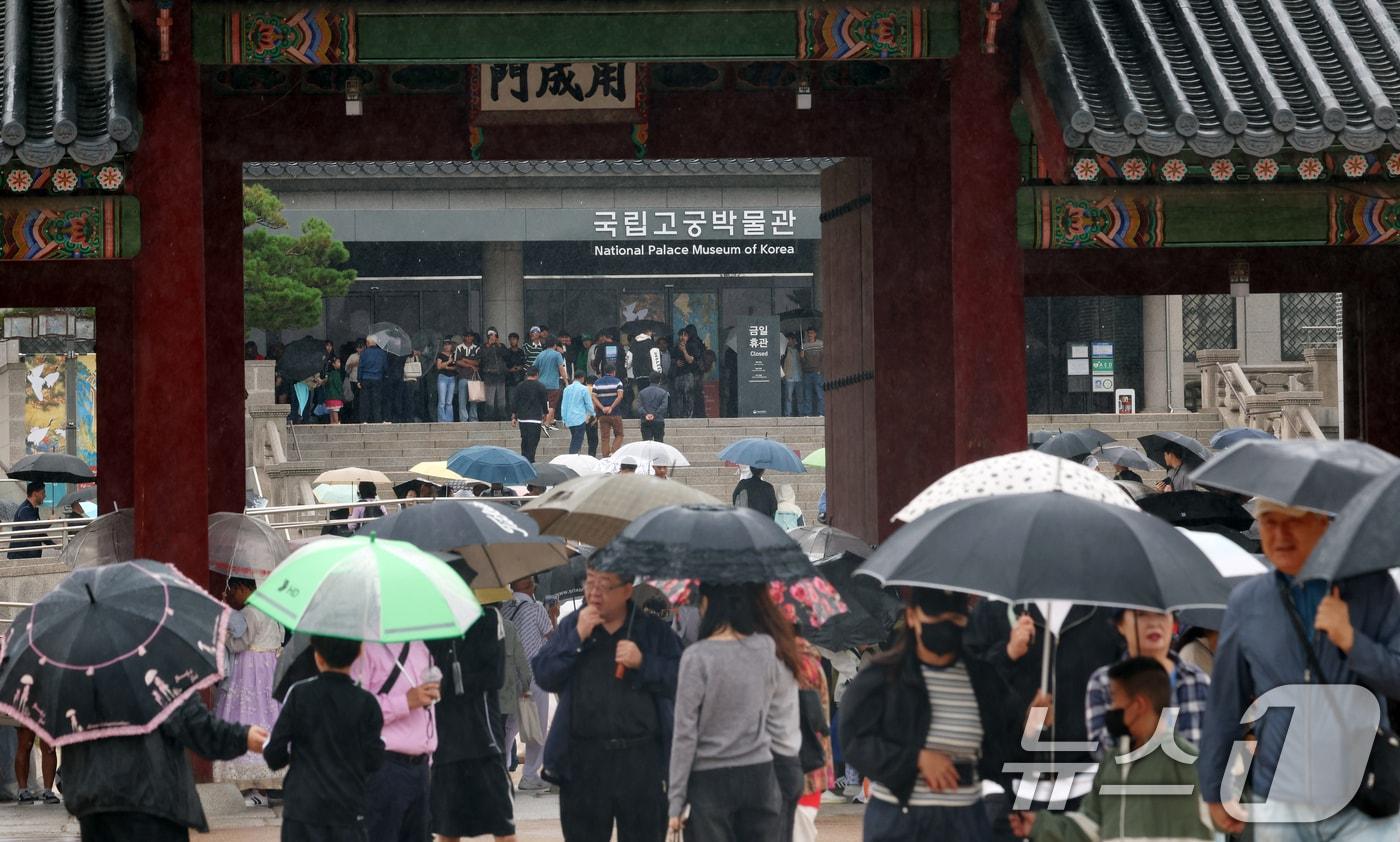 추석인 6일 서울 종로구 경복궁에서 비가 내리는 가운데 시민들과 외국인 관광객들이 나들이를 하고 있다. 추석 연휴 기간동안 경복궁, 창덕궁, 덕수궁, 창경궁 등 4대 궁과 종묘, 조선왕릉이 무료로 개방되어 누구나 자유롭게 관람할 수 있다. 2025.10.6/뉴스1 ⓒ News1 김명섭 기자