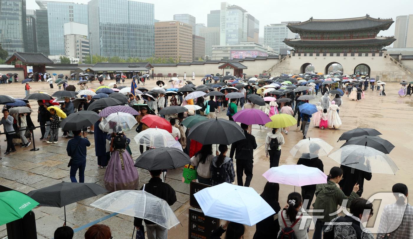 추석인 6일 서울 종로구 경복궁에서 비가 내리는 가운데 시민들과 외국인 관광객들이 나들이를 하고 있다. 추석 연휴 기간동안 경복궁, 창덕궁, 덕수궁, 창경궁 등 4대 궁과 종묘, 조선왕릉이 무료로 개방되어 누구나 자유롭게 관람할 수 있다. 2025.10.6/뉴스1 ⓒ News1 김명섭 기자