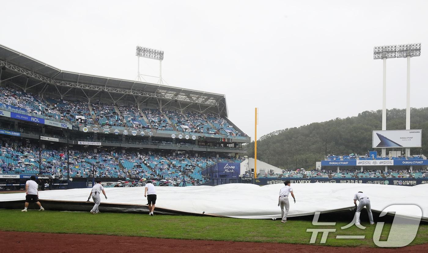 7일 오후 대구 삼성라이온즈파크에서 열리는 프로야구 2025 신한 SOL뱅크 KBO 와일드카드 결정전 2차전, 삼성 라이온즈와 NC 다이노스의 경기를 앞두고 비가 내리자 경기 진행요원들이 방수포를 덮고 있다. 2025.10.7/뉴스1 ⓒ News1 공정식 기자