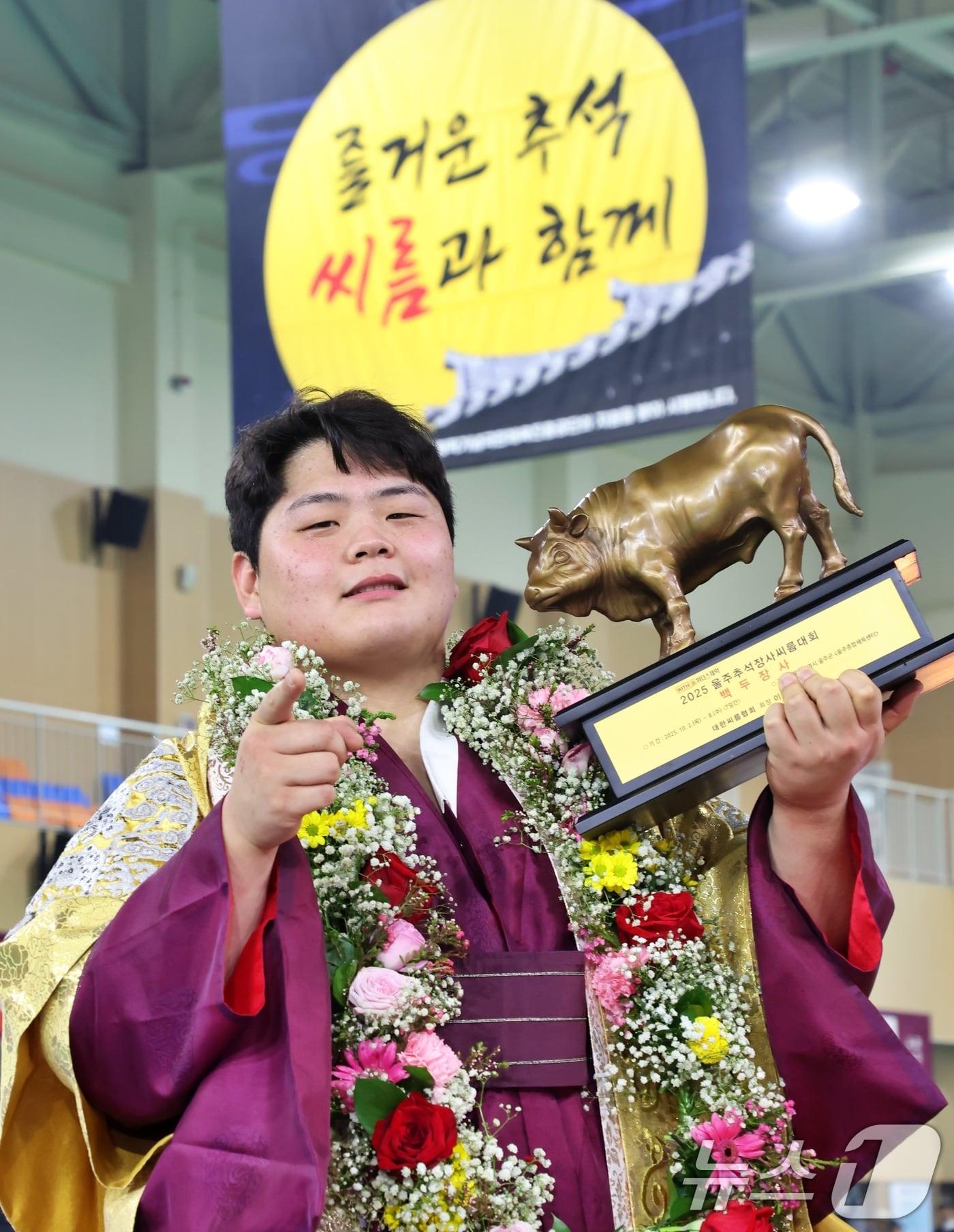 본문 이미지 - 8일 울산광역시 울주군 울주종합체육센터에서 열린 ‘위더스제약 2025 울주추석장사씨름대회’ 백두장사&#40;140kg이하&#41;에 등극한 김민재&#40;영암군민속씨름단&#41;가 황소트로피를 들고 기념사진을 찍고 있다. 2025.10.8/뉴스1