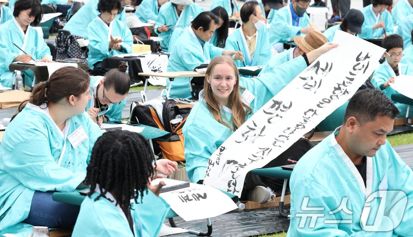 제579돌 한글날을 맞이한 9일 서울 종로구 광화문광장에서 열린 ‘2025 제 16회 광화문광장 휘호대회‘에 참가한 외국인들이 한글을 쓰고 있다. 이번 대회는 총 35개국 약 400여명이 참가했다. 2025.10.9/뉴스1 ⓒ News1 이호윤 기자